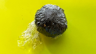 再び新しいラップに包み、包み終わりの方を下にして5分置いて海苔をなじませている