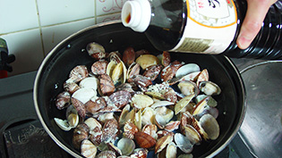 貝の口が半分開いたタイミングで醤油をたらしている
