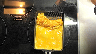 表面が半熟状になったら、卵焼きを奥から手前に半分に畳む