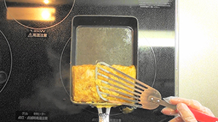 ヘラで少し押さえて卵焼きの形を整える