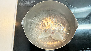鯛の切り身を熱湯にサッとくぐらせて霜降りしている