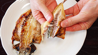 グリルで焼いたアジの干物を、手で皮と骨を取り除きながら身を粗くほぐしている