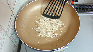 白胡麻をフライパンに入れて中火で乾煎りしている