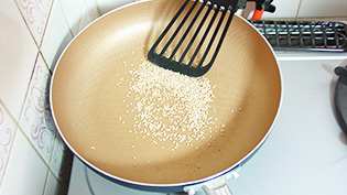 白胡麻をフライパンに入れて中火で乾煎りしている