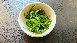 青じそは茎を取り、丸めて千切りにする