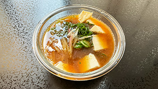 油を軽く切ったツナ、きゅうり、青じそ、みょうがを入れ、絹豆腐をスプーンですくって加え、混ぜる