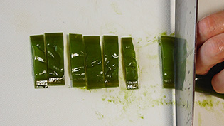 塩抜きした茎わかめの水気を切って斜めに薄く切る