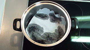 紙の落し蓋をして豆が煮汁から出ないようにする
