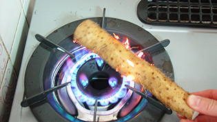 ガスコンロで軽くあぶってひげ根を焼いている