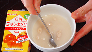 電子レンジで温めたお湯にドライイーストと砂糖を入れてかき混ぜる