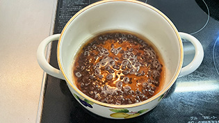 沸騰したら弱火にして、3〜4分煮て赤い煮汁を作っている