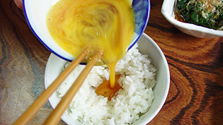 卵をご飯のくぼみに流し込んでいる