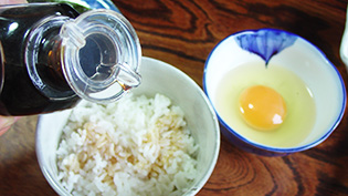 卵より先に醤油を熱々のご飯にかけている