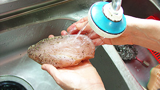 流水で塩を洗い落としている