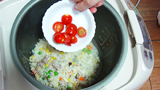 コンソメと塩とトマトを加え、炊飯器のスイッチを入れる