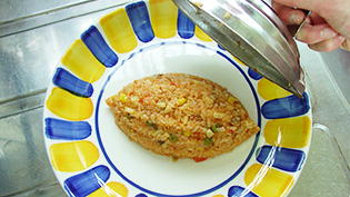 お皿にチキンライスをよそっている