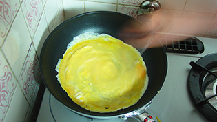 中弱火で10秒かき混ぜ、半熟卵を作っている