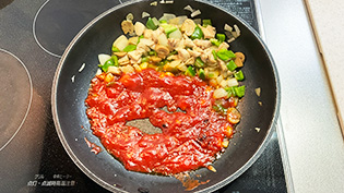 フライパンの空いたところにトマトケチャップとサラダ油(焼きケチャップ用)を加えて炒め、煮詰めて水分を飛ばしているところ