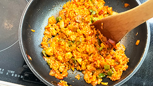 温かいご飯を加えて強火で炒め合わせ、塩・こしょうで味をととのえている